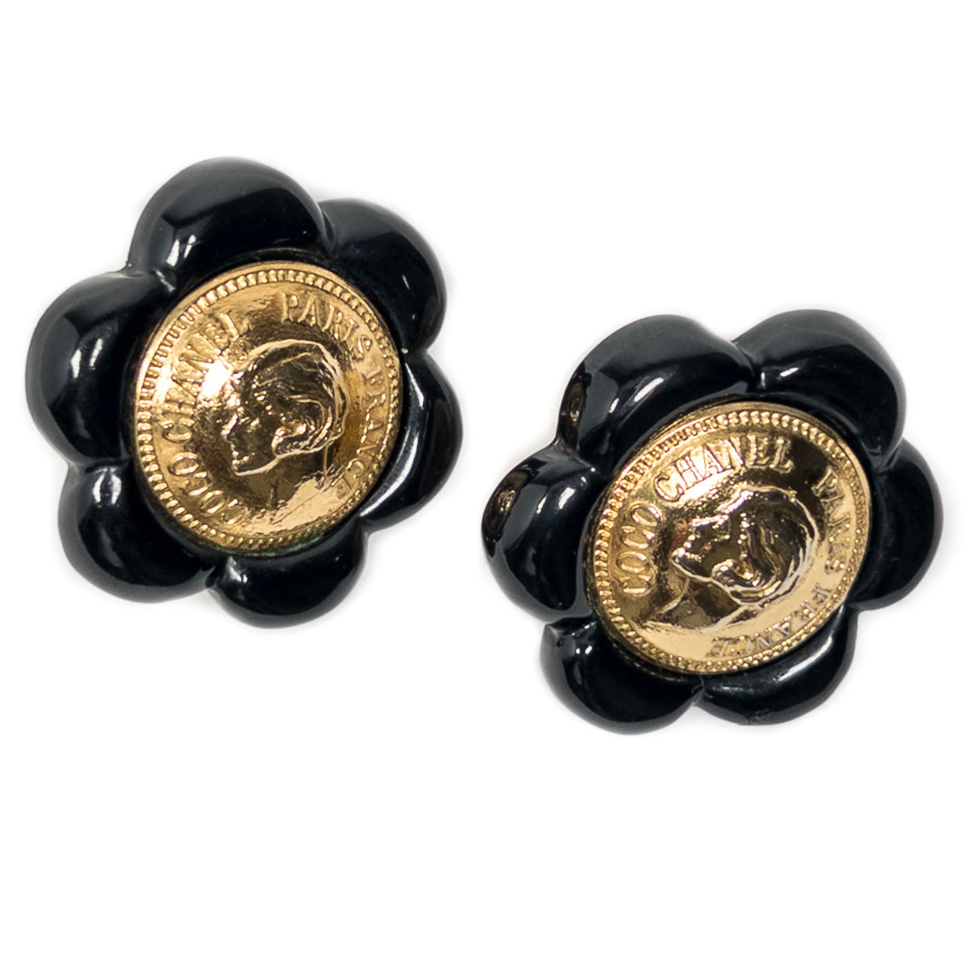 Vintage Chanel Earrings Black Camelia Coco Cameo Clip 1984
A pair of vintage Chanel black camellia clip earrings featuring a golden cameo design.