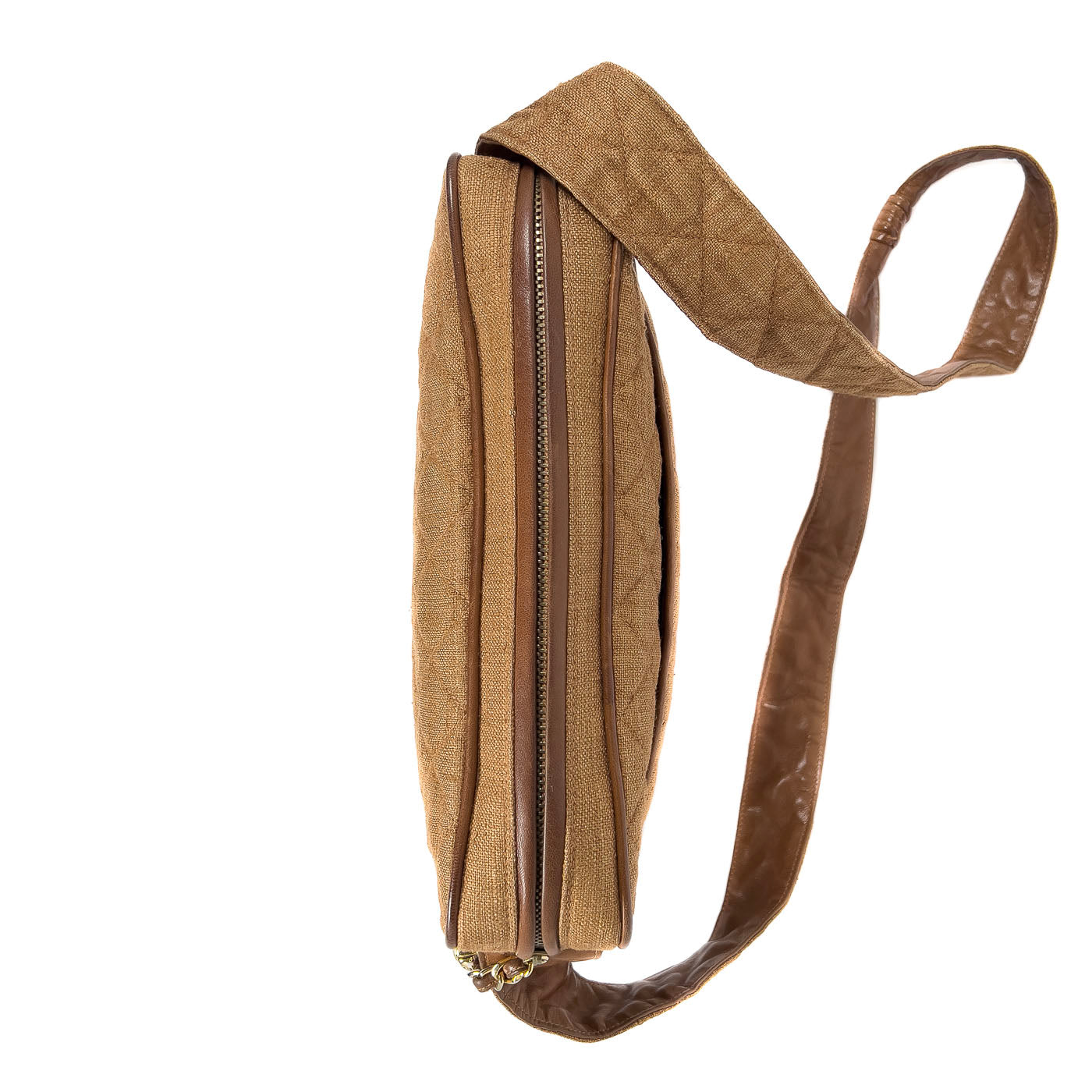 A vintage Chanel camera bag in camel brown with a quilted design, large stitched CC logo, and a tassel.