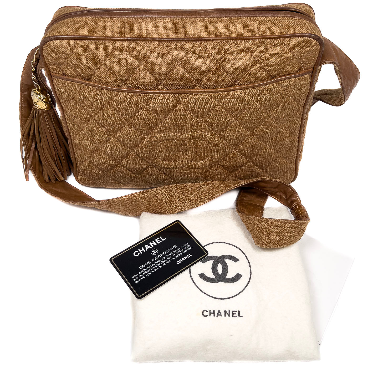 A vintage Chanel camera bag in camel brown with a quilted design, large stitched CC logo, and a tassel.