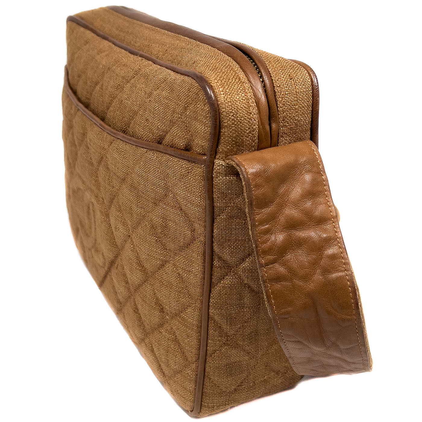 A vintage Chanel camera bag in camel brown with a quilted design, large stitched CC logo, and a tassel.