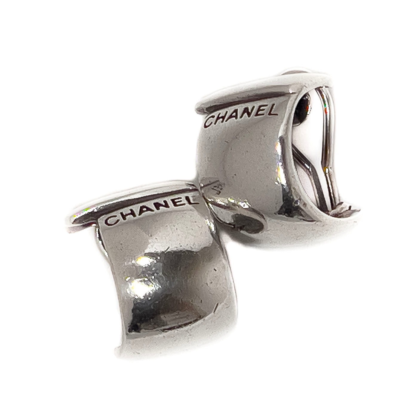 A pair of vintage Chanel sterling silver clip earrings with a sleek, curved wraparound design.