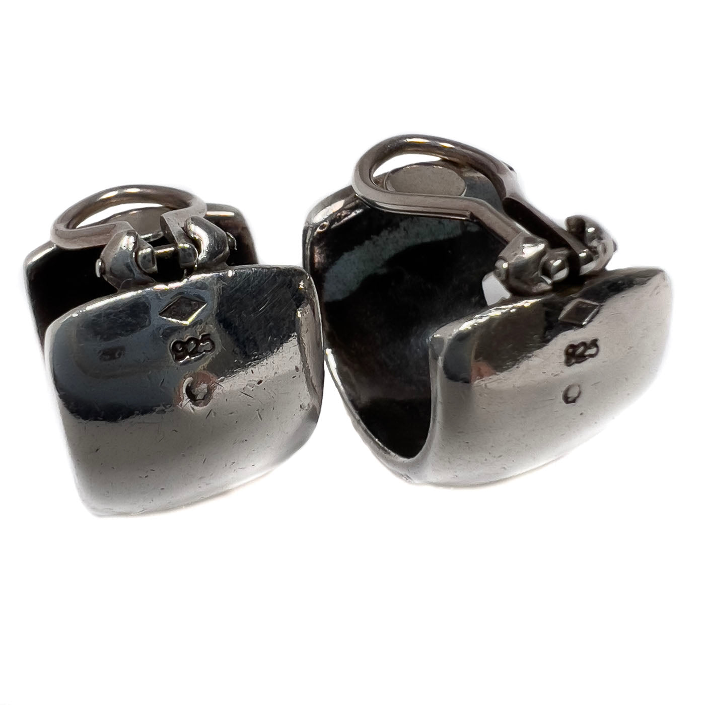 A pair of vintage Chanel sterling silver clip earrings with a sleek, curved wraparound design.