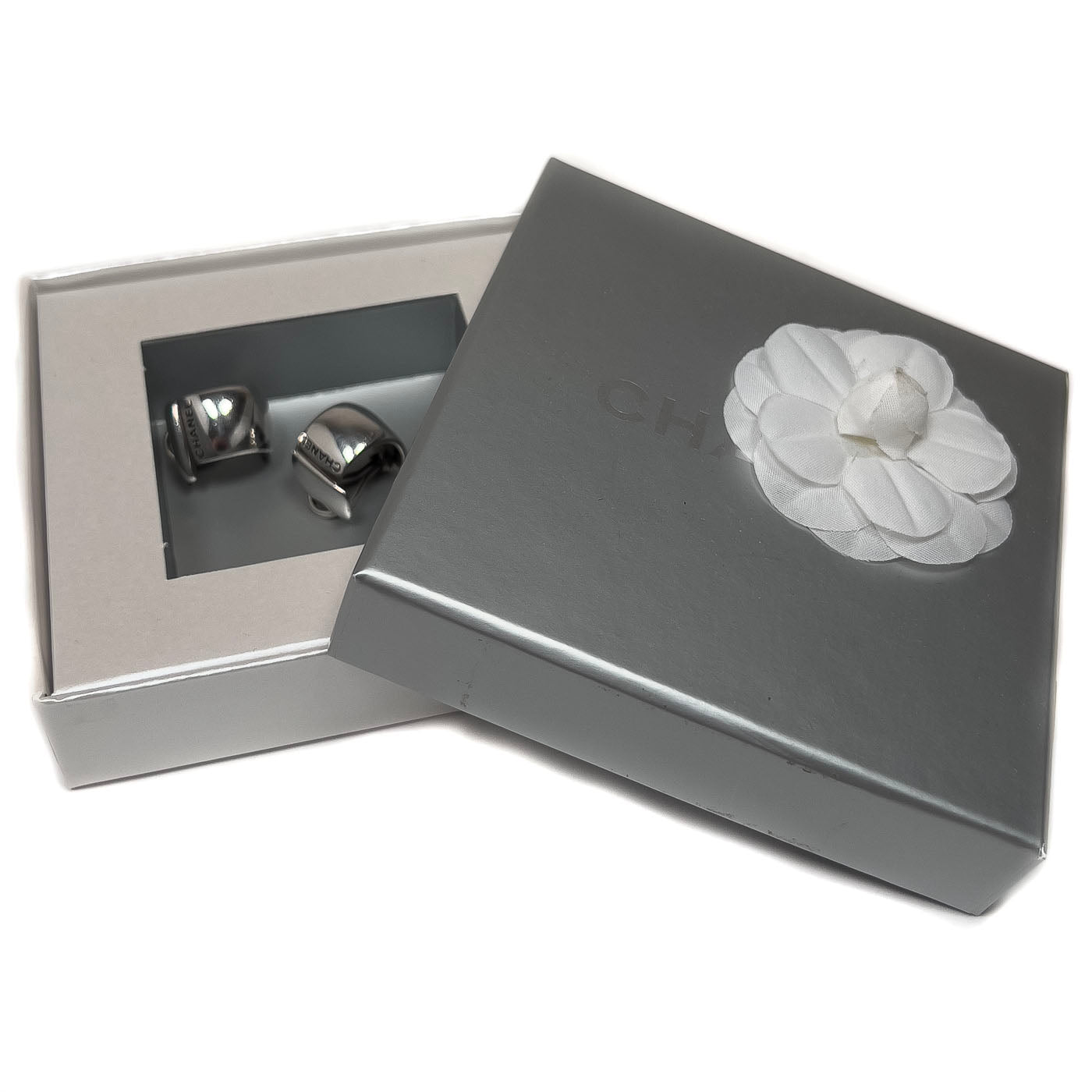 A pair of vintage Chanel sterling silver clip earrings with a sleek, curved wraparound design.