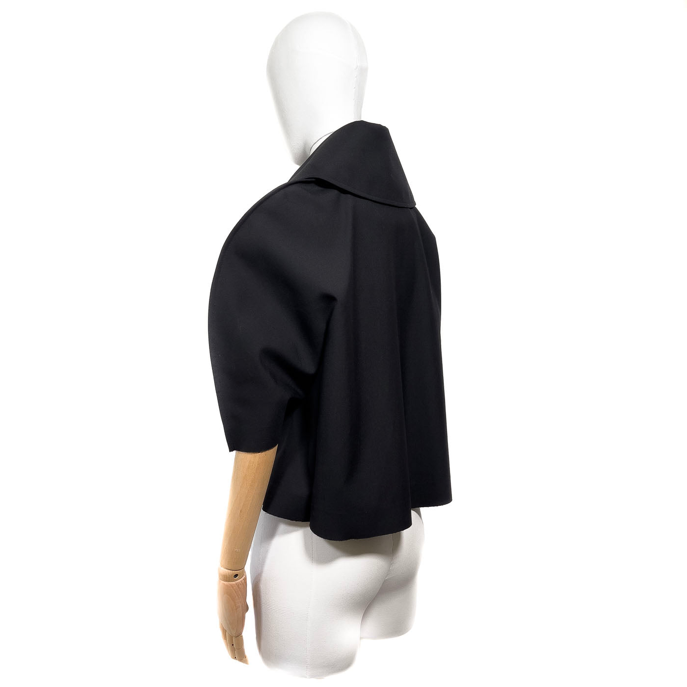 Comme des Garçons Jacket JUNYA WATANABE Black JPN M.
A black short cape jacket with a mandarin collar and short sleeves, displayed on a mannequin.