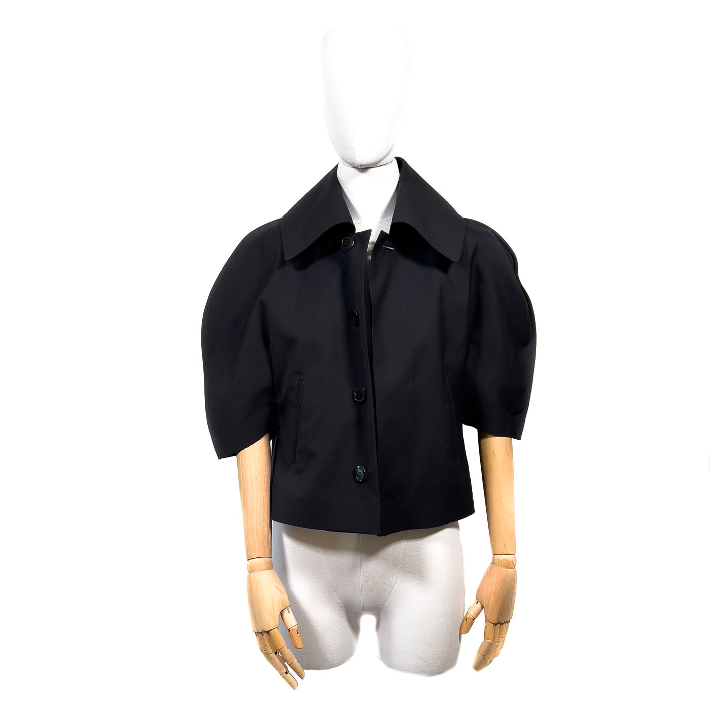 Comme des Garçons Jacket JUNYA WATANABE Black JPN M.
A black short cape jacket with a mandarin collar and short sleeves, displayed on a mannequin.