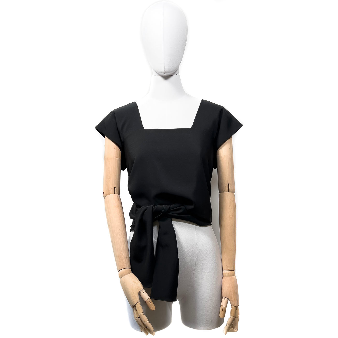 Pre-owned Chanel Boutique black wrap-around top displayed on a mannequin, featuring a wrap-around design with a tie at the waist.