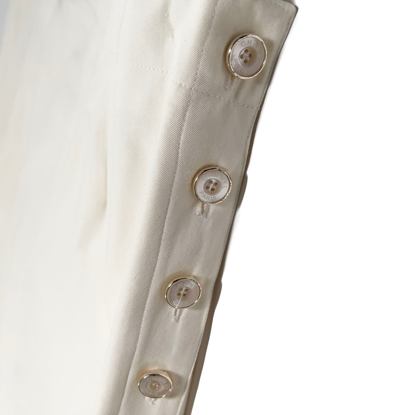 A pair of vintage Chanel Boutique ivory white trousers with button accents, displayed on a plain background.