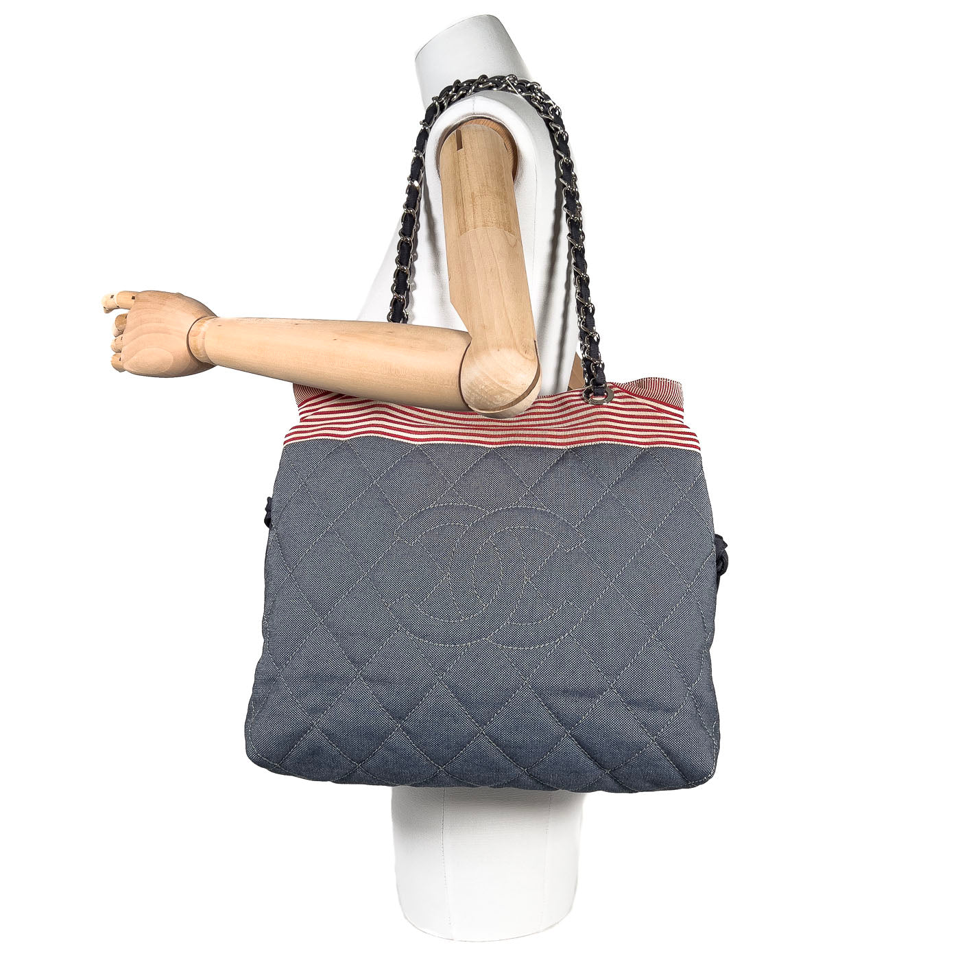 Pre-owned Chanel CC Tote Bag in blue denim with red and white striped accents, silver-tone hardware, drawstring and magnetic button closure.