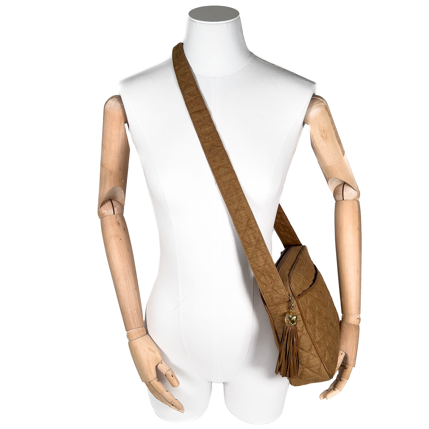 A vintage Chanel camera bag in camel brown with a quilted design, large stitched CC logo, and a tassel.